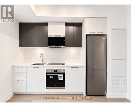 A modern kitchen with white cabinets and a black range hood.