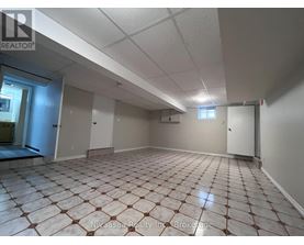 A spacious room with tiled flooring and white walls.