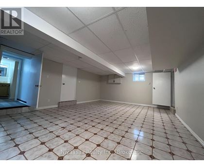 A spacious room with tiled flooring and white walls.