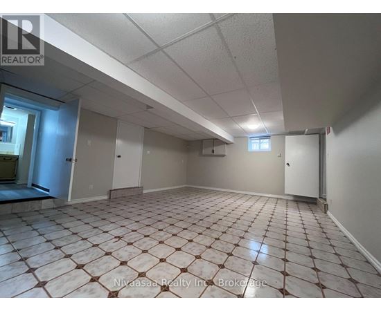 A spacious room with tiled flooring and white walls.