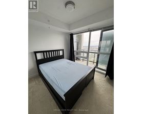 A bedroom with a large bed and a view of the city.
