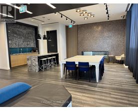 A modern dining room with a long table and chairs.