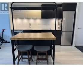 A modern kitchen with a wooden table and bar stools.