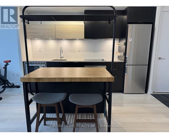 A modern kitchen with a wooden table and bar stools.