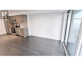 A kitchen with a refrigerator, microwave, and oven.