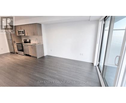 A kitchen with a refrigerator, microwave, and oven.