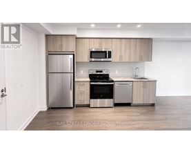 A modern kitchen with a refrigerator, oven, microwave, and sink.