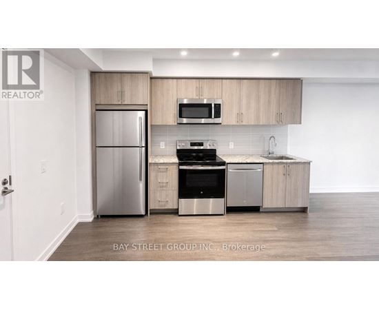 A modern kitchen with a refrigerator, oven, microwave, and sink.
