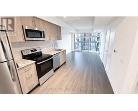 A kitchen with a refrigerator, oven, and microwave.