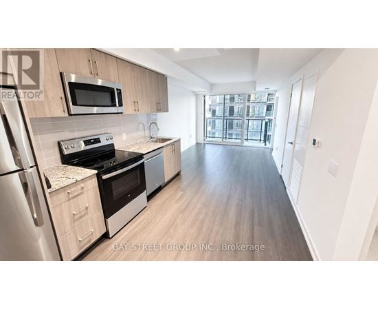 A kitchen with a refrigerator, oven, and microwave.