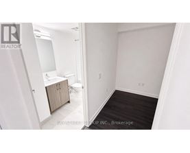 A white bathroom with a toilet, sink, and cabinet.