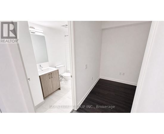 A white bathroom with a toilet, sink, and cabinet.