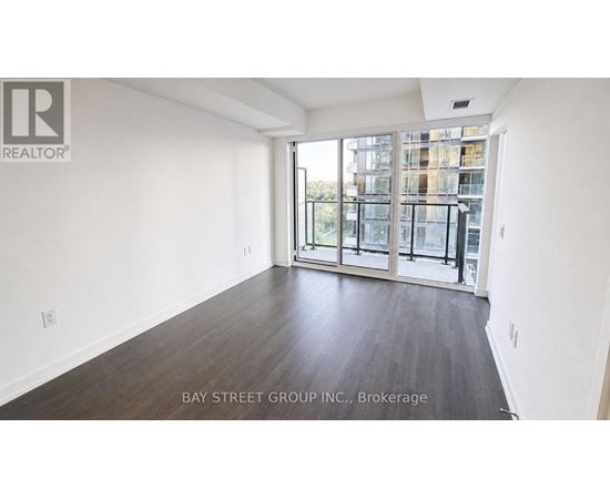 A spacious room with a view of a cityscape through large windows.