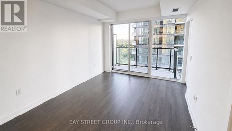 A spacious room with a view of a cityscape through large windows.