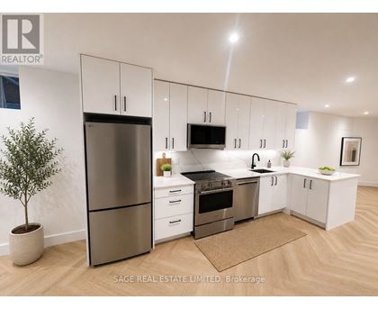 A modern kitchen with white cabinets and stainless steel appliances.