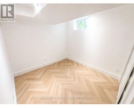 A room with a herringbone patterned floor and white walls.