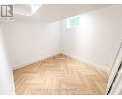 A room with a herringbone patterned floor and white walls.