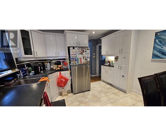 A kitchen with white cabinets and a black counter top.