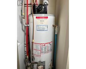 A tankless water heater is installed in a narrow space.