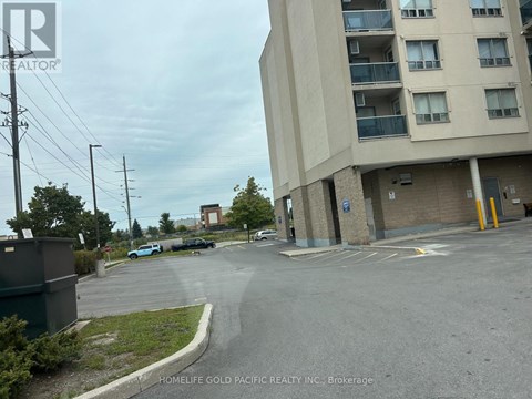 A parking lot in front of a building with a sign that says "HOMELIFE GOLD PACIFIC REALTY INC., Brokerage".