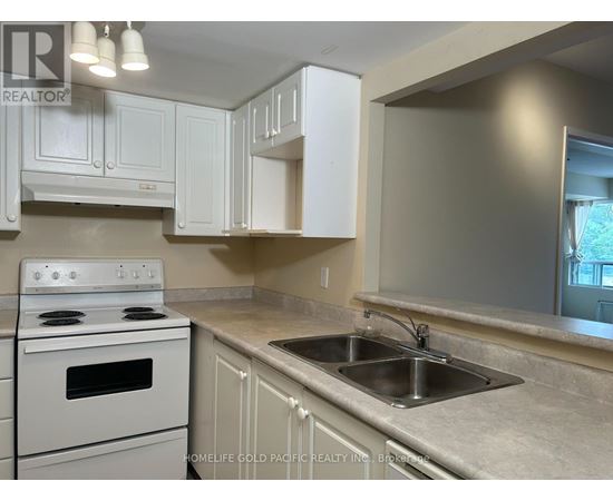 A kitchen with a white stove and cabinets.