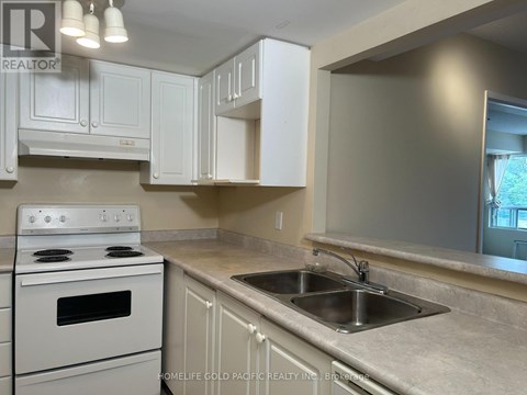 A kitchen with a white stove and cabinets.