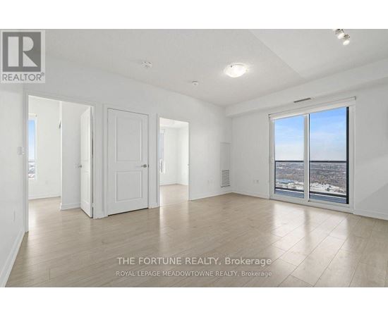 A large, empty room with a view of the city through a large window.