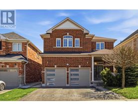 A brick house with a garage is for sale.