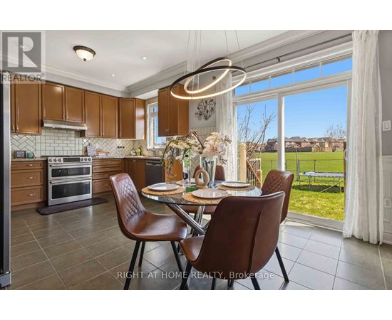 A well-lit kitchen with brown chairs and a table set for two.