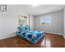 A bedroom with a bed and a painting on the wall.