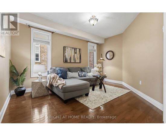 A living room with a grey couch and a wooden floor.