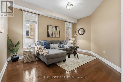 A living room with a grey couch and a wooden floor.