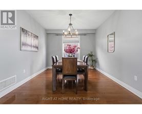 A dining room with a wooden table and chairs.
