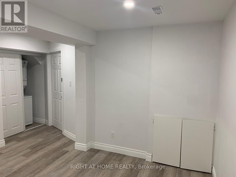 A room with a white wall and a wooden floor.