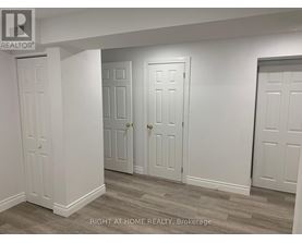 Three white doors in a room with a brokerage logo.