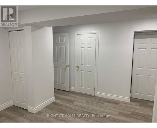 Three white doors in a room with a brokerage logo.