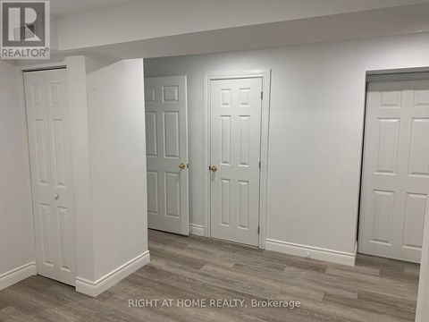 Three white doors in a room with a brokerage logo.