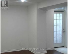 A room with white walls and a door leading to a hallway.