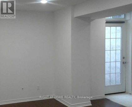 A room with white walls and a door leading to a hallway.