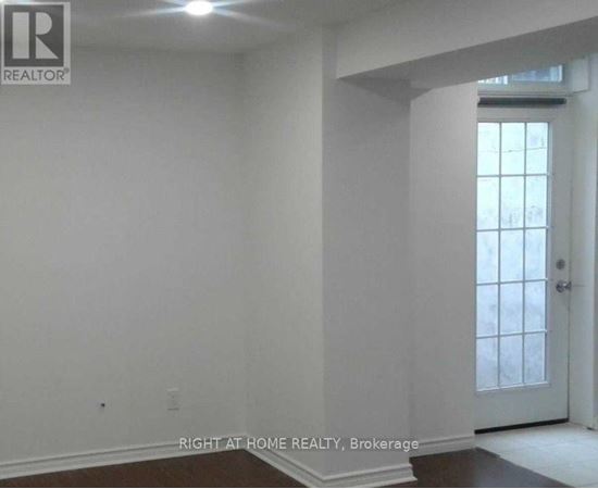 A room with white walls and a door leading to a hallway.
