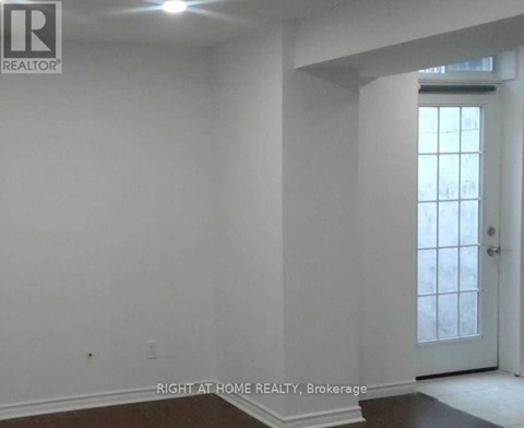 A room with white walls and a door leading to a hallway.