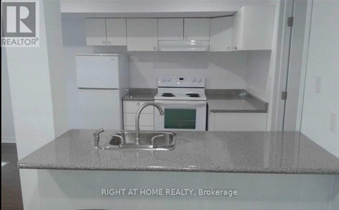 A kitchen with a stove top oven and a sink.