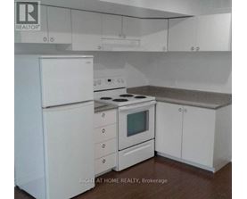 A white kitchen with a stove and refrigerator.