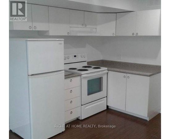 A white kitchen with a stove and refrigerator.