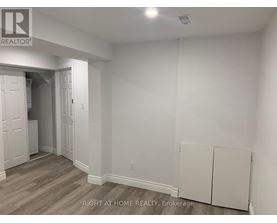 A room with a white wall and a wooden floor.