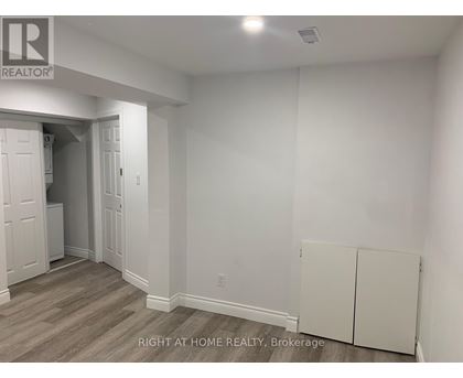 A room with a white wall and a wooden floor.