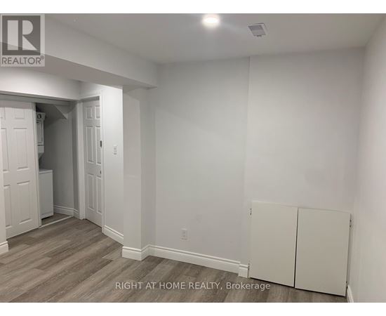 A room with a white wall and a wooden floor.