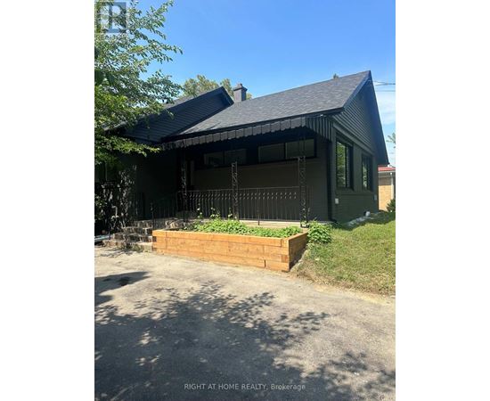A house with a black roof and a wooden planter box in front.