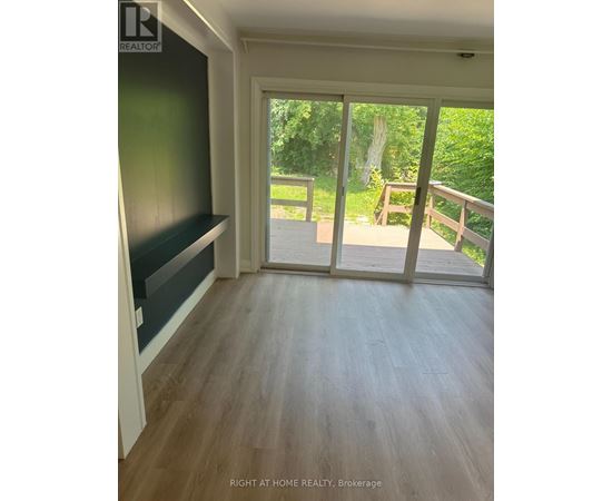 A room with a sliding glass door leading to a deck.