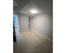 A room with a wooden floor and a white wall.